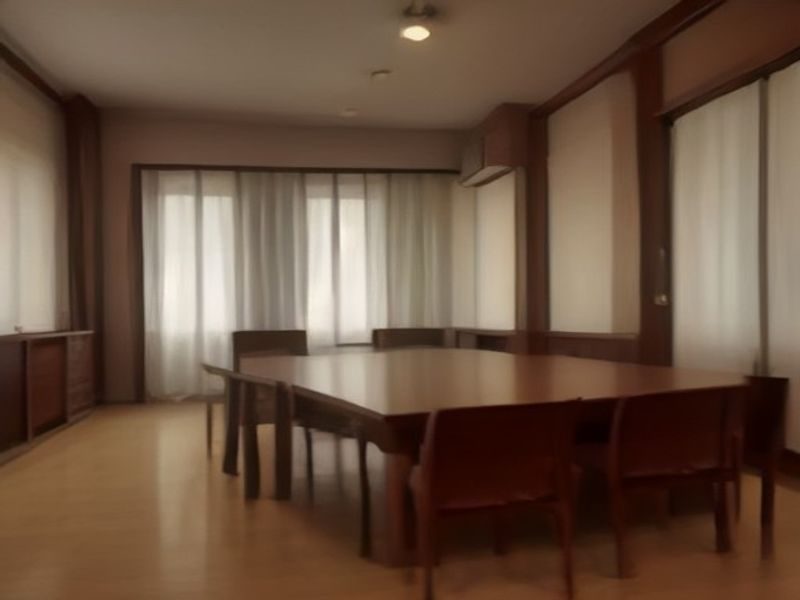 暗色调私密健康训练室内，一位专业私密教练正为学员讲解训练计划表